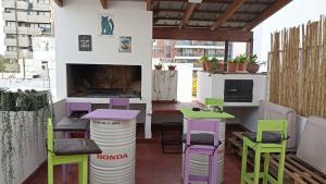 eine Terrasse mit bunten Stühlen und Tischen sowie einem Kamin in der Unterkunft Casamundocba in Cordoba