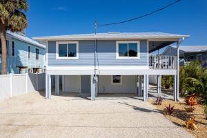 a blue and white house with a balcony at Welcome to Ostego Beach Vacation Rental - 253 Ostego home in Fort Myers Beach