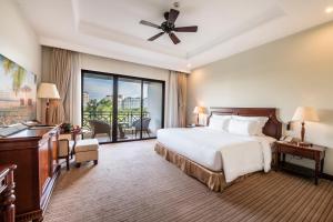 a hotel room with a bed and a balcony at Vinpearl Resort & Spa Phu Quoc in Phu Quoc