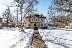 a white house with snow on the ground at Marmora and Lake Inn and Victorian Diner in Marmora