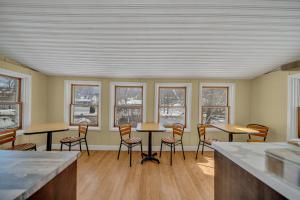 a room with chairs and tables and windows at Marmora and Lake Inn and Victorian Diner in Marmora