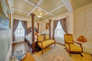 a bedroom with a bed and a chair and a table at Marmora and Lake Inn and Victorian Diner in Marmora