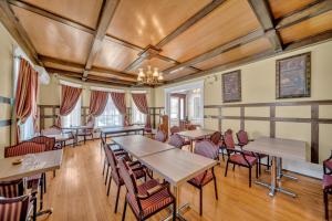 a dining room with tables and chairs and a chandelier at Marmora and Lake Inn and Victorian Diner in Marmora