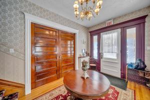 a living room with a wooden door and a table at Marmora and Lake Inn and Victorian Diner in Marmora