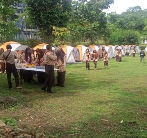a group of people standing around a table with tents at Puncak Camp Hills in Bogor