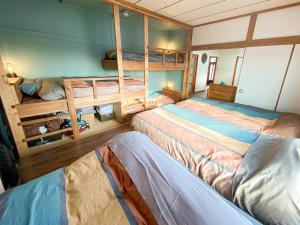 a bedroom with two beds and two bunk beds at Port Front ポートフロント 釣りに最適 in Shikyū