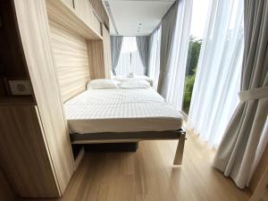 uma pequena cama num quarto com uma janela em Garden Pod at Gardens by the Bay em Singapura