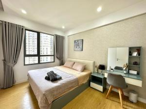 a bedroom with a bed and a desk and a chair at 1,2 BEDROOM in MASTERI THAO DIEN in Ho Chi Minh City