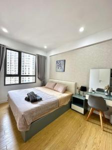 a bedroom with a bed and a desk with a chair at 1,2 BEDROOM in MASTERI THAO DIEN in Ho Chi Minh City