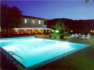 a large swimming pool in front of a house at Hotel Villalago trasimeno in Magione