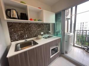 a kitchen with a sink and a washer and dryer at D condo sign A72 in Chiang Mai