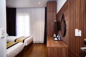 ハロンにあるNavy Hotel Ha Longのベッド2台と窓が備わるホテルルームです。