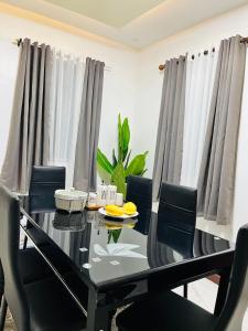 une salle à manger avec une table et des chaises noires dans l'établissement Stanford Resedence, à Silang