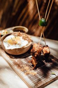 a plate of food with meat and a bowl of dip at Hilltop Cabanas in Komari