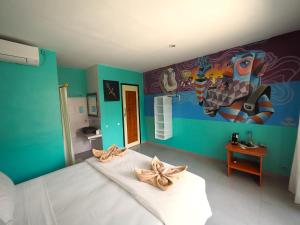 Habitación con cama y pintura en la pared en Dragon Dive Komodo Dive Resort en Labuan Bajo