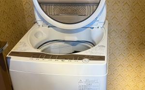 a white washing machine sitting in a room at COFFEE HOTEL Soundwave in Fujisawa