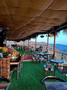 un restaurante al aire libre con mesas y sillas en el césped en Al Misfah Hospitality Inn, en Misfāh
