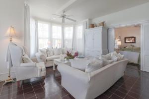 a living room with white furniture and white chairs at Folly home in Governorʼs Harbour