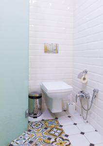 a bathroom with a toilet and a tile floor at Park Hotel Kokshetau in Shchūchīnsk
