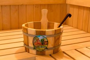 a wooden bucket with a wooden spoon in a sauna at Park Hotel Kokshetau in Shchūchīnsk