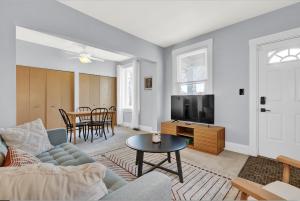 een woonkamer met een bank, een tv en een tafel bij Cozy Cottage in the Heart of Hyde Park home in Cincinnati