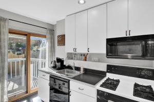 a kitchen with a sink and a microwave at Cozy Cottage in the Heart of Hyde Park home in Cincinnati