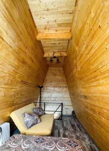 a room with a bed in a wooden ceiling at Cabana A-Frame Refugiu Montan in Băişoara