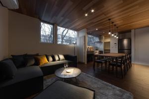 a living room with a couch and a table at Le Sauna Villa Hakuba in Hakuba