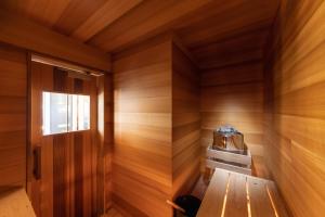 una sauna con pared de madera y puerta en Le Sauna Villa Hakuba en Hakuba