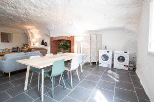 cocina y sala de estar con mesa y lavadora en Maison troglodyte - Le Cerisier Perché en Luynes