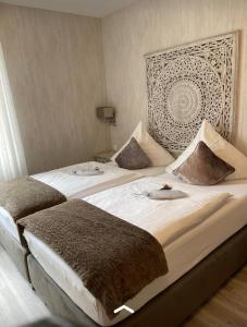 a bedroom with two beds with pillows on them at Hotel Haus Loewe in Frechen
