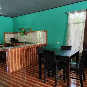 cocina con mesa, sillas y fregadero en Alba House, en Puerto Jiménez