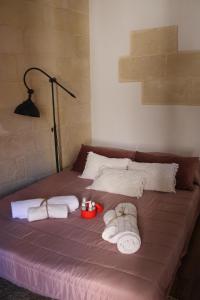 un letto con asciugamani, candele e lampada di BETÌ a Taranto