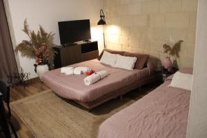 a bedroom with two beds and a flat screen tv at BETÌ in Taranto