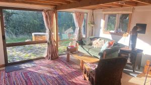 a living room with a couch and a fireplace at Alpacas Off Grid - Eco Cabin in Takaka