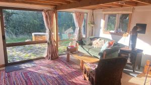 a living room with a couch and a fireplace at Alpacas Off Grid - Eco Cabin in Takaka