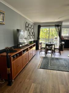 uma sala de estar com uma televisão e uma mesa de jantar em Mahalo BnB em Mapleton