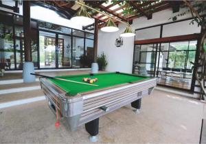 a pool table in a large room with windows at Khaoyai Valley1 บ้านพักเขาใหญ่วัลเล่ย์1 in Mu Si