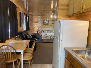 a kitchen with a refrigerator and a table in a room at Cox Cabin On The River in Red River
