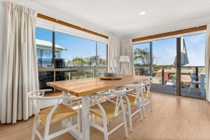 a dining room with a table and chairs and a large window at Badhuset in Smiths Beach