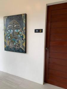 un tableau sur un mur à côté d'une porte dans l'établissement The Great Molave DELUXE ROOM, à Cavite
