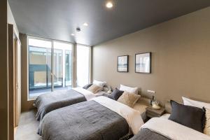 a bedroom with three beds and a couch at nabe cape in Tagawa