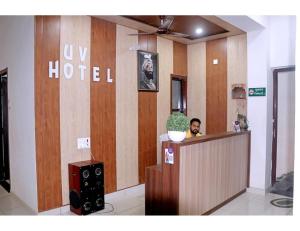 Hotel UV, Haryana في Nārnaul: وجود امرأة جالسة في مكتب الاستقبال في فندق