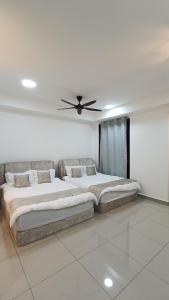 een slaapkamer met 2 bedden en een plafondventilator bij bali residensi in Melaka