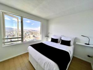 a bedroom with a large bed with a large window at Departamento para empresas y grupos in Calama