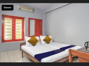 1 dormitorio con 1 cama con almohadas amarillas y azules en KKP Tourist Home en Thiruvananthapuram