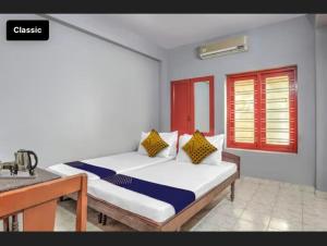 a bedroom with a bed and a table and a window at KKP Tourist Home in Trivandrum