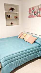 a bed in a white room with blue sheets at Casetta Nilu' in Procida