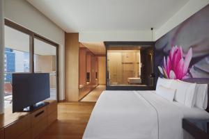 una camera con un grande letto e una televisione di The Westin Hyderabad Mindspace a Hyderabad