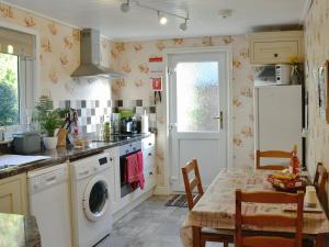 a kitchen with a washing machine and a table at Bryn Rodyn in Llanfair-Dyffryn-Clwyd